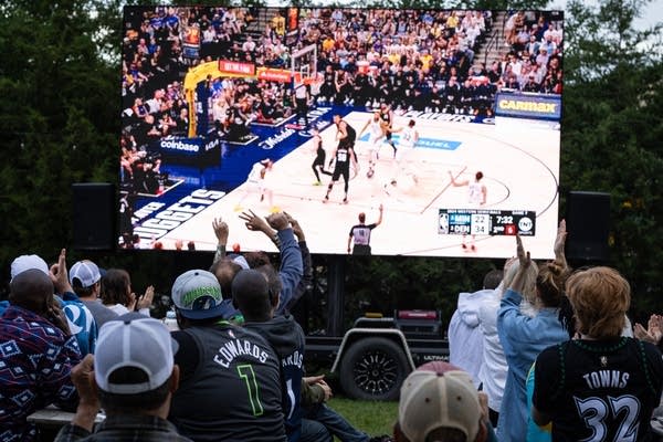 人们在观看篮球比赛时举起手