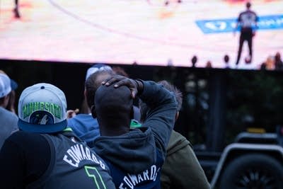 一名男子在观看篮球比赛时将手放在头上